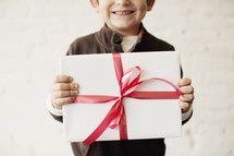 a young boy holding a wrapped present 