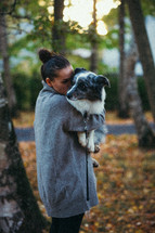 Woman carrying her dog on a walk