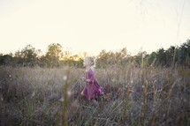 a toddler girl running through tall grasses 