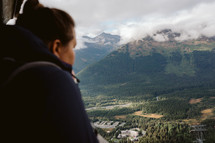 Woman's profile in blurry foreground with mountains in the background