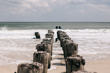 old pier posts on a beach 