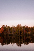 fall trees reflecting on lake water 
