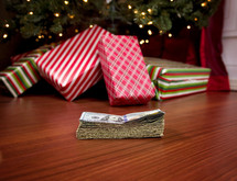 cash in front of a Christmas tree 