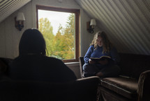 Two women reading her Bible in a quiet room with natural window light