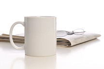 coffe mug, newspaper, and reading glasses 