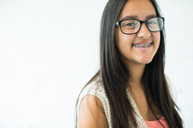 smiling teen girl with braces and glasses 