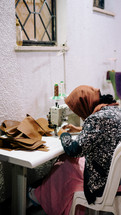Woman using a sewing machine in a leather workshop