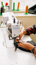 Woman sewing a zipper on to fabric with a sewing machine