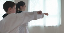 Slow motion footage of young kids practicing martial arts.