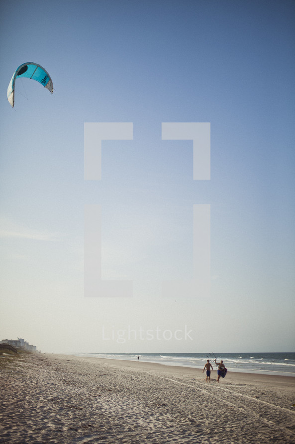 Teenagers flying a kite on the beach
