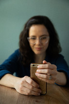 a woman looking at a cellphone screen 
