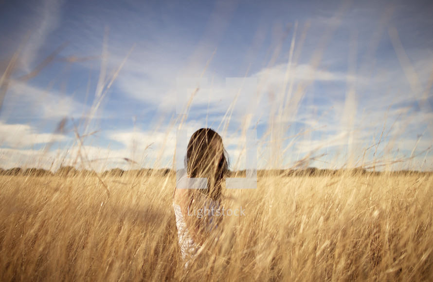 Girl sitting in wheat field
