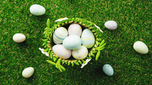 Basket of painted easter eggs on green grass