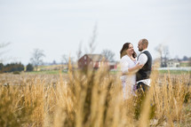 couple standing in a field hugging