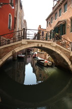 woman standing on a bridge over a canal in Venice 
