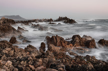 ocean water around rocks on a shore 