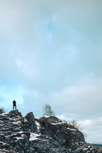 a man standing at the edge of a rock cliff 