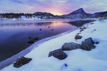 soft colorful light coming over the mountain tops along Lake estes shoreline in a spring or winter morning