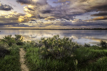 Dramatic clouds roll over the Colorado lake as the sun starts to rise on the horizon