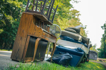 furniture and debris on the side of a road - cleaning up after flood damage 