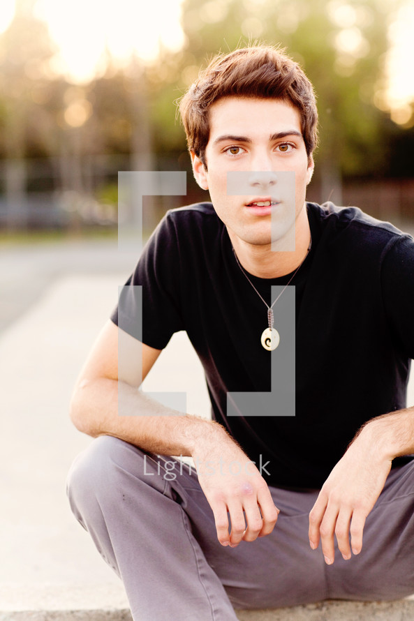 Young man sitting teen model fashion brown hair Caucasian white