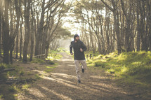 a man running on a path in a forest 
