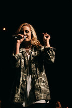 teen girl singing into a microphone 