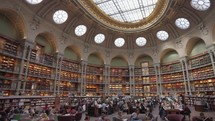 Paris, France - March 19, 2024: The Salle Ovale at the Bibliothèque Nationale de France, Richelieu an elegant oval room wood-paneled walls and beautiful ceiling, adorned with valuable book collection