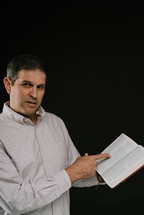 man reading from a Bible 