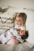 big sister holding a newborn baby 