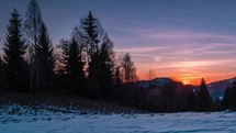 Colorful morning sunrise in frozen forest nature in winter mountains landscape time lapse