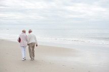 Elderly couple walking along the beach