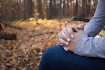 woman with praying hands outdoors in fall 
