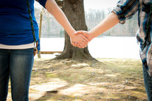 a couple holding hands outdoors 
