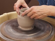 potter forming clay on a potter's wheel 