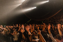 young women with raised hands at a concert

