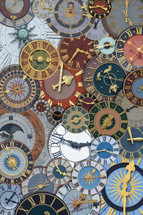 multicolored collection of ancient church tower clocks on a pile in different sizes and forms with roman numbers