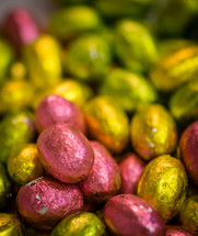 Chocolate Easter eggs covered in pink and yellow foil paper.