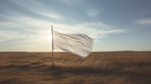 White surrender flag blowing in the wind in field.