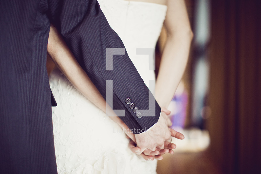 A wedding couple holding hands