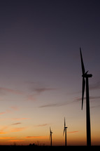 Silhouettes of windmills at sunset