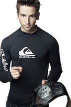 Champion; man in black rash guard holding a championship belt, pointing towards the camera.