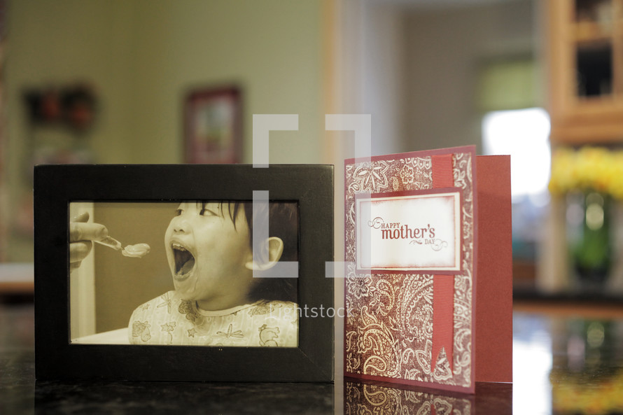 Happy Mother's day card and a framed photo of a mother feeding a baby