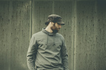 side profile of a man in a hoodie and cap 