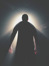 musician on stage standing under spotlights 