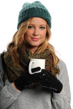 woman in winter hat, scarf, and gloves drinking hot cocoa 