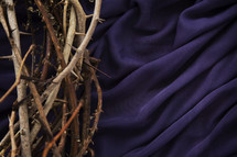 a crown of thorns on purple cloth.