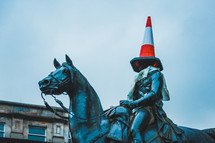 statue with a cone on its head 