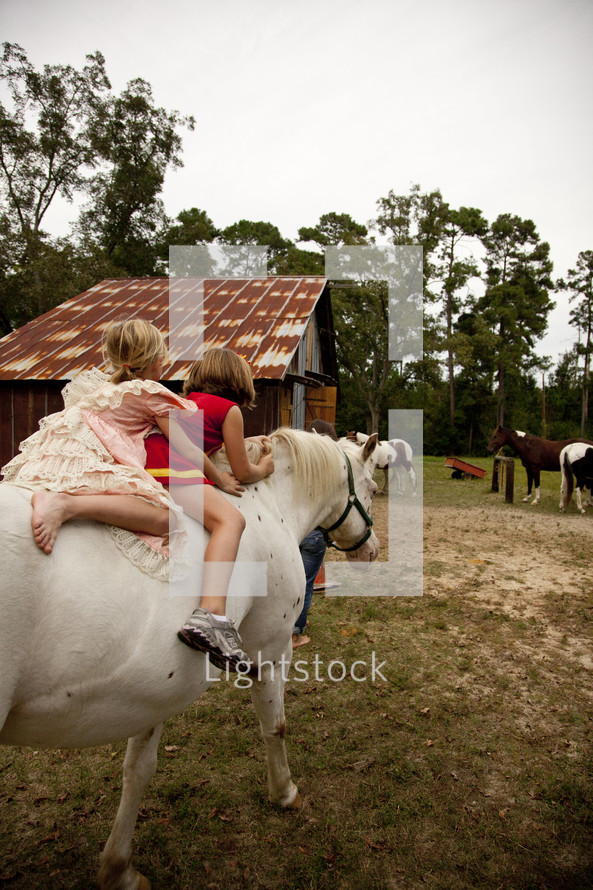 two kids riding a horse bare back
