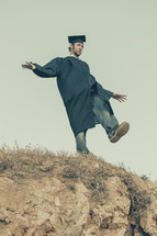 graduate balancing on a hill